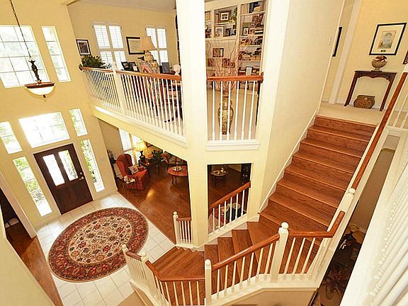Gleaming hardwood stairway with bonus room that is overlooking entryway