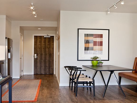 Spacious living area featuring sustainable wood-plank style flooring