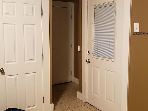 Main entryway in the center, second exit on the right. Bathroom door on the left.