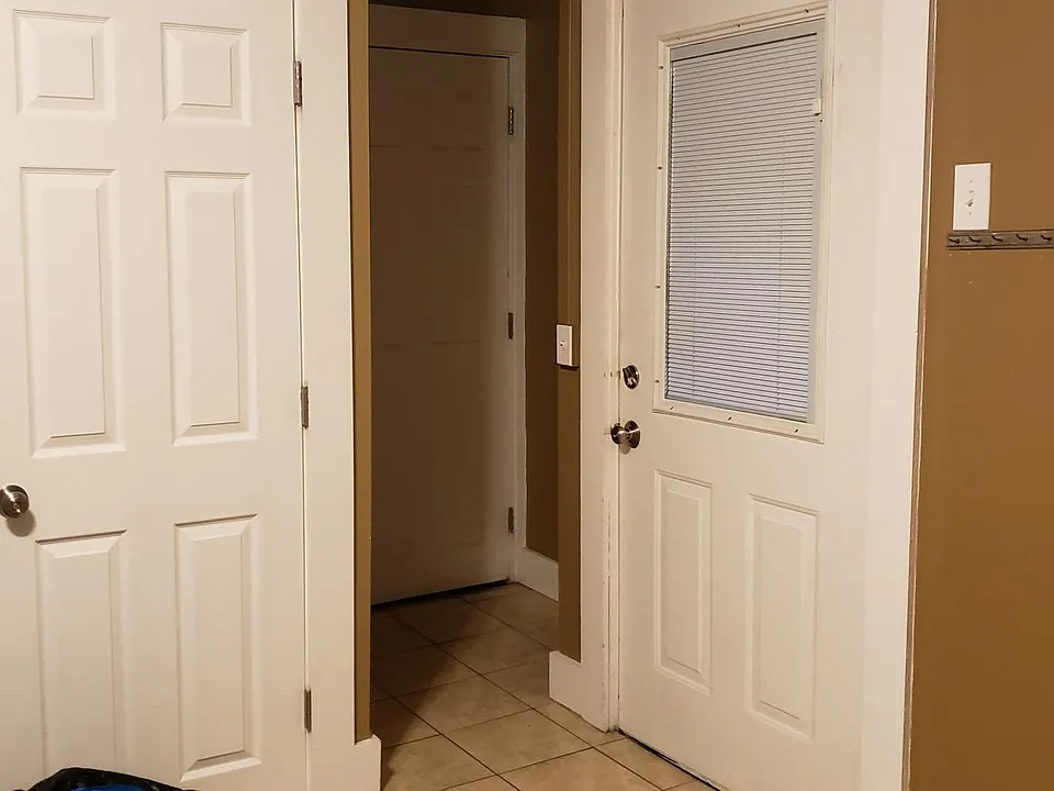 Main entryway in the center, second exit on the right. Bathroom door on the left.