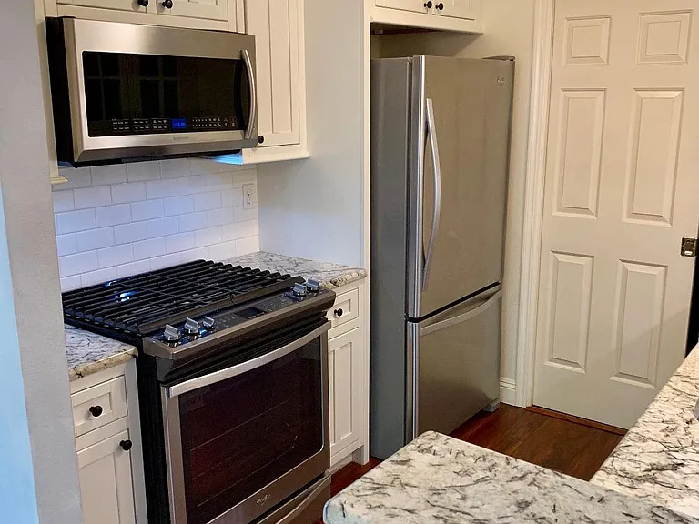 Kitchen has microwave, bottom freezer refrigerator, chef's stove and Bosch dishwasher. Stainless sink has Lady Luxe faucet.
