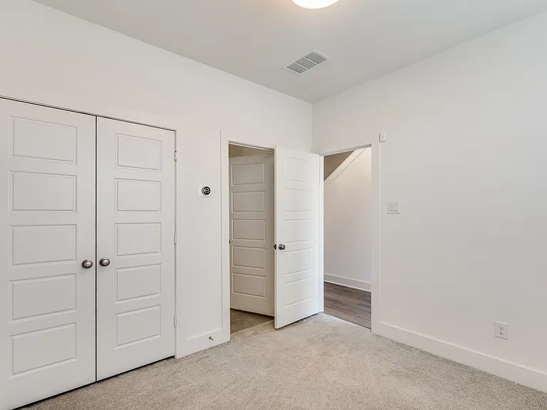 Bedroom #1 with large closet and lots of natural sunlight showing the entrance to the private en suite full bathroom.