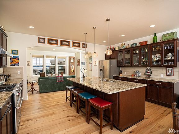 Spacious gourmet kitchen featuring granite counters, soft-close custom cabinets, polished nickel fixtures and high-end appliance