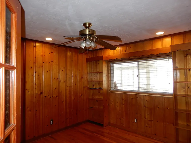 Pine wood paneling and builtin book shelves and recessed ceiling lights.
Can be used as bedroom or home office.