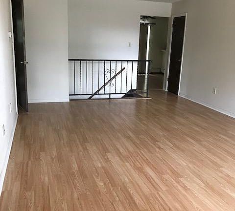 Living room with new laminate flooring installed, viewed from front door.