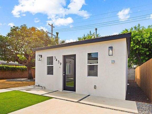 The unit includes dedicated outdoor space behind a beautiful avocado tree