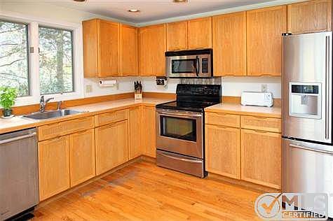 Another view of the kitchen with stainless steel appliances.