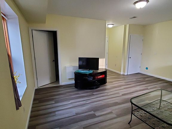 Large sized living room with 2 windows, a lot of natural air and light. TV with TV stand is included. Leads into the backyard.