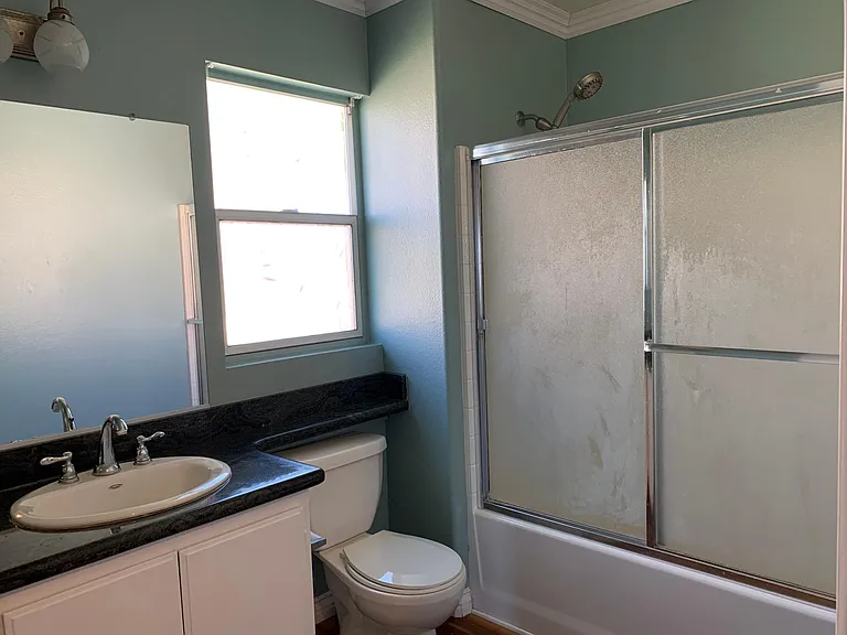 Shared bathroom on 2nd floor with hardwood floor and granite countertop.