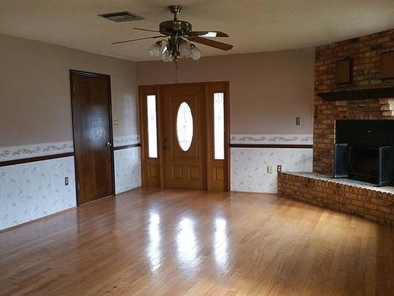 Family Room with Brick, Wood-Burning Fireplace and Wood Floors.