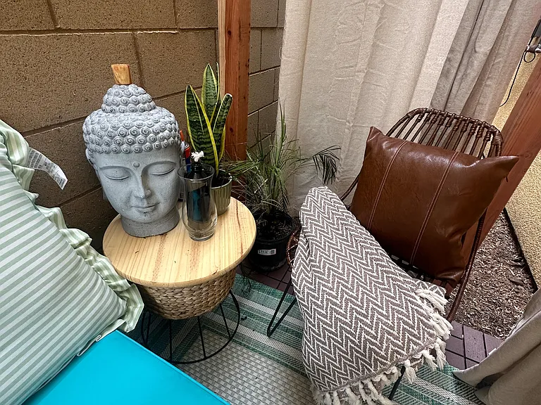 Private patio nook with outdoor seating, side table, and greeneryan inviting spot to relax or enjoy fresh air.