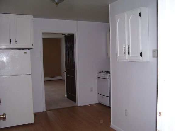 Kitchen with stove and refrigerator and room for a table.