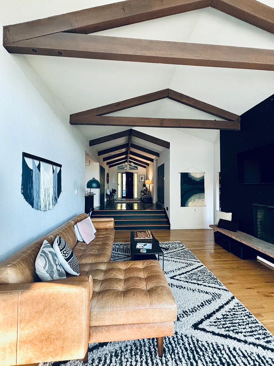Sunken living room with wood burning fireplace, high beams, and lots of natural light. - 2980 Interlocken Dr
