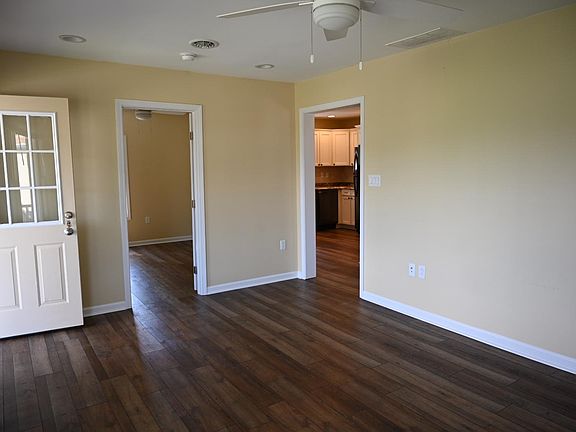 Large living room located in the front of the house with the first bedroom off to the side.