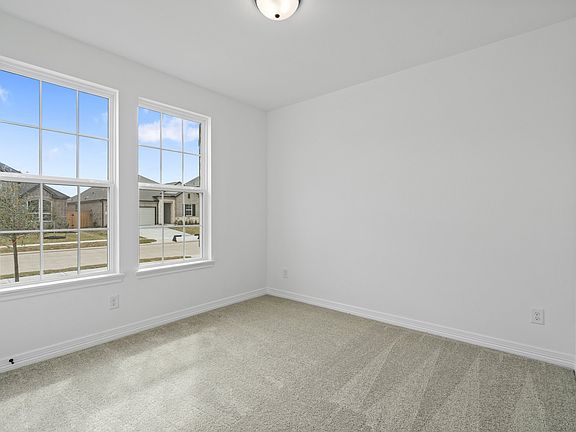 The secondary bedroom features plush carpet, fresh paint, closet, and a large window that lets in pl