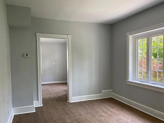 Spacious family room filled with natural light, featuring large windows, updated flooring, and fresh neutral paint. An inviting space perfect for relaxing, entertaining, or working from home.