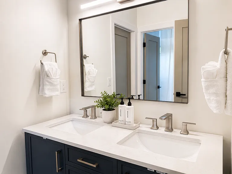 Queen bedroom with calming blackout curtains, smart TV, bedside charging, plush bedding, spacious walk-in closet, seating, and a private, restful suite-style feel.