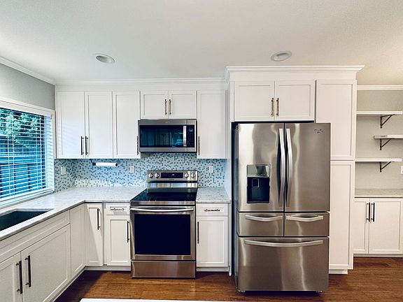 Remodeled kitchen with stainless appliances, huge island, and marble countertops!