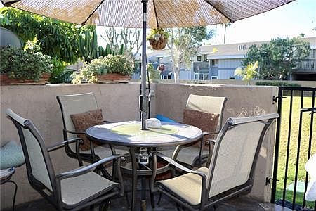 patio with included furniture and gate to golf course type greenbelt