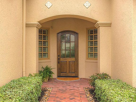 The wooden front door entrance has a security camera that allows you to see who is arriving at your 