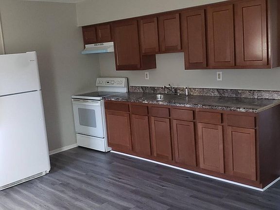 Kitchen with brand new cabinets, sink, counter top, flooring and oven