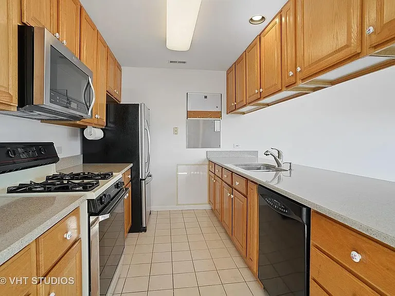 Kitchen with refrigerator, stove, microwave, and dishwasher. ceram ic floor. Island overlooking living room.