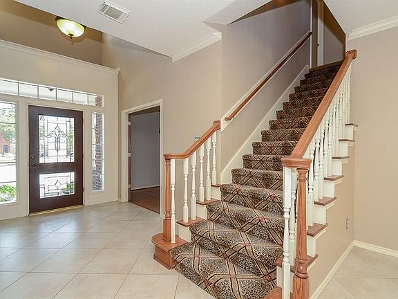 Neutral wide tile laid on the diagonal greet you as you enter this beautiful home. Custom carpet on the front stairs.  Yes, there is also a back stair case near kitchen.