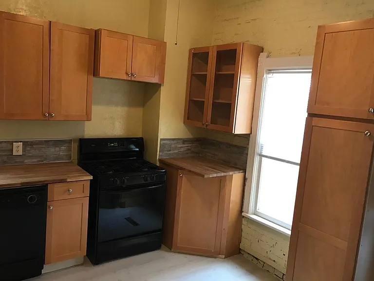 Kitchen, beyond in back is main floor laundry and bathroom with shower