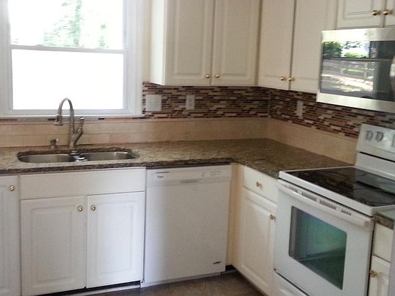 Kitchen w/ granite counters, marble floor, tile backsplash