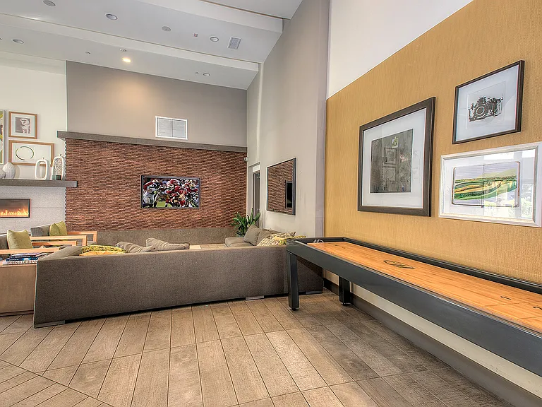 Modern lobby and resident entry with natural wood finishes at Aster Apartments.