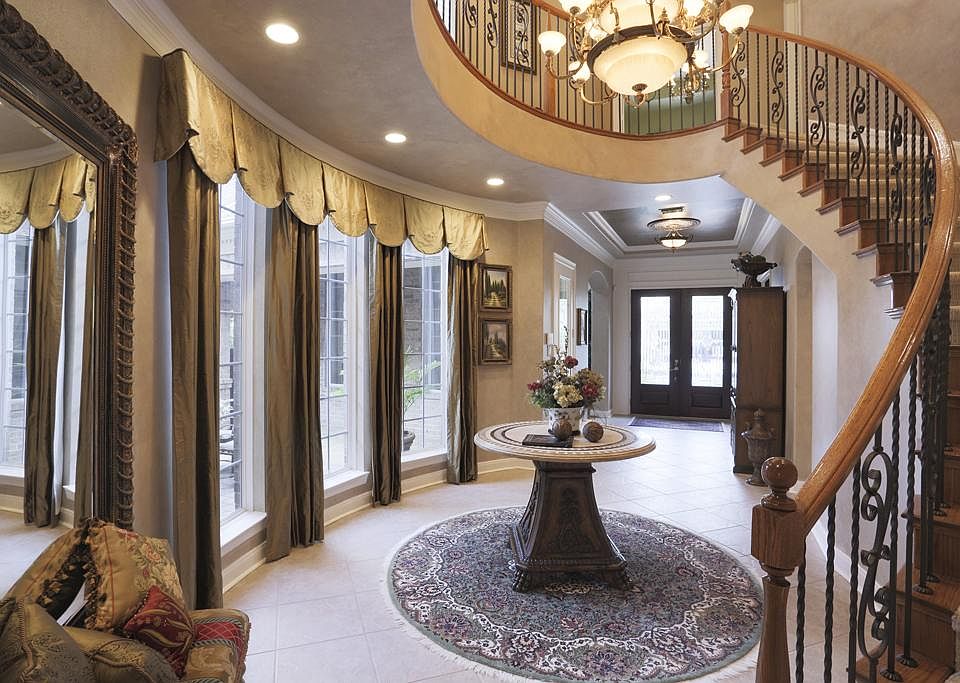 Stunning entry with stately staircase, abundance of natural light and custom window coverings finish