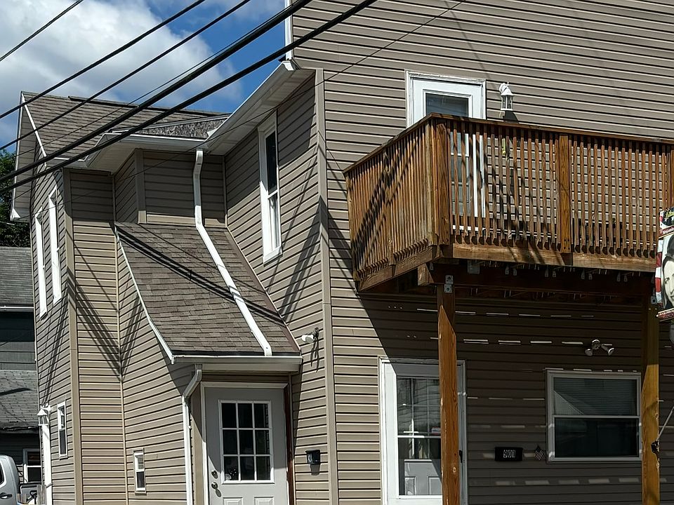 Front door to the right under deck. Back door is to the left beyond trash cans.