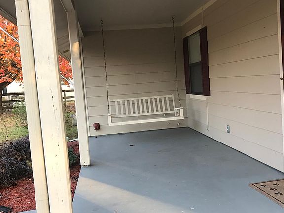 Front porch, nice swing to enjoy large covered porch and fenced in front yard.