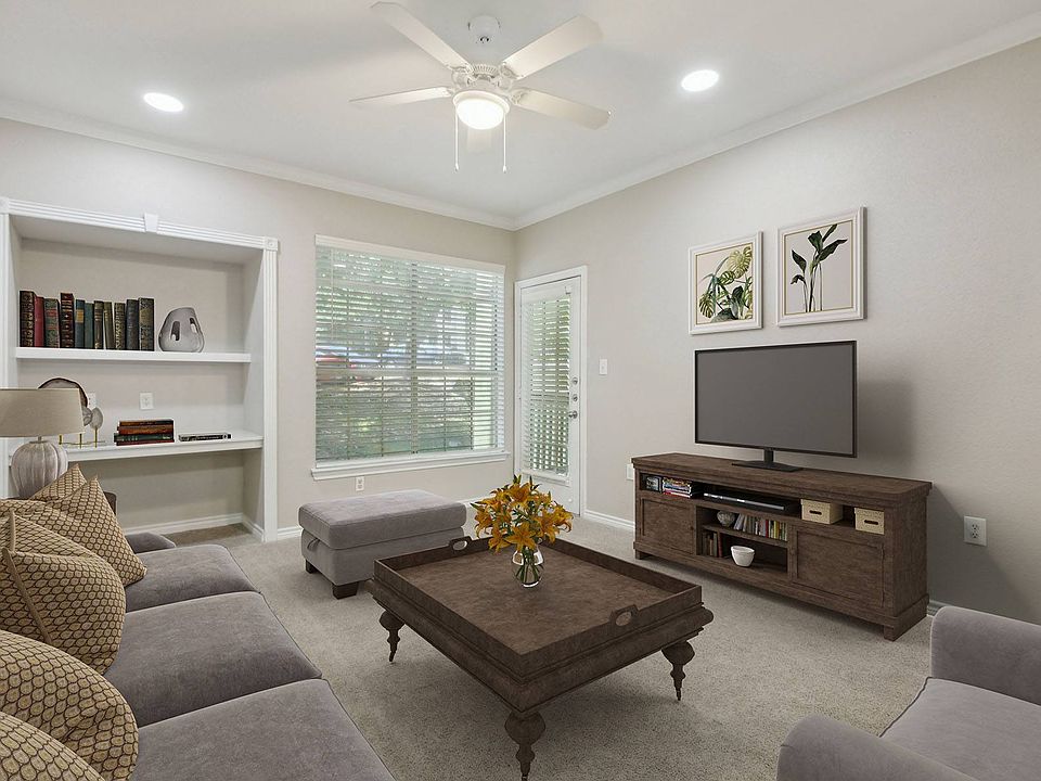 Living room with plush carpeting and built-in bookshelf