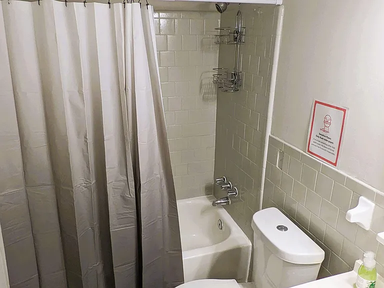 Full bath with a tub/shower combo, tiled surround, and a vanity with storage for everyday essentials.