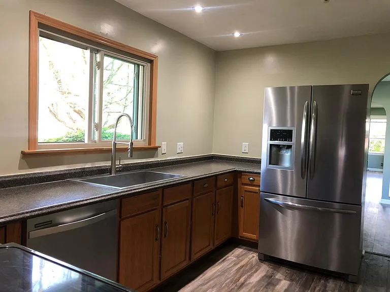 Full kitchen view. Custom made oak shelf above sink.