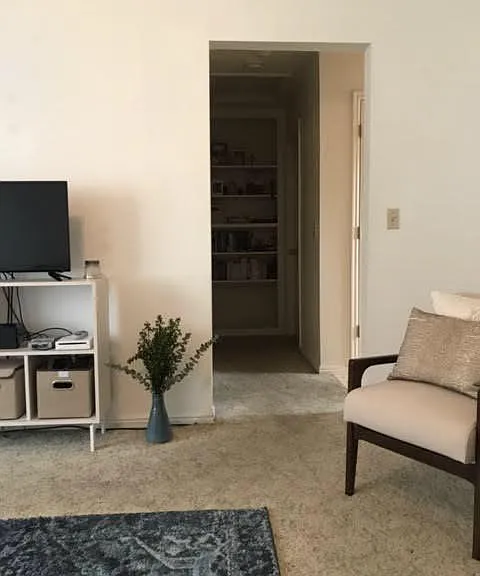 Living room, looking down hallway. Built in shelving at end of hall.