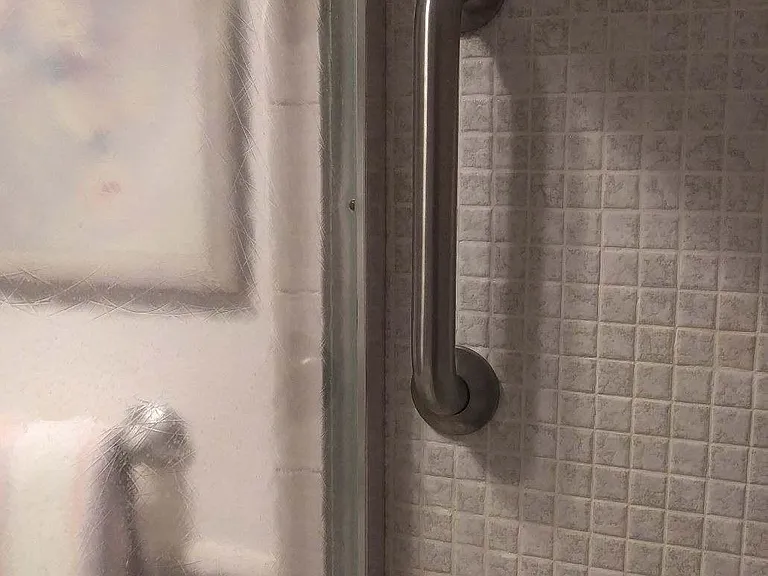 Short grab bar near shower door to assist with stepping into or out from the shower base.