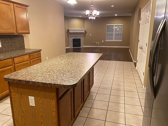 Kitchen (u-shaped) with a large island in the middle. (photo taken from the corner, just left of sink) In the background is the Great Room. This shows the view from the West side of the house, all the way to the East side.