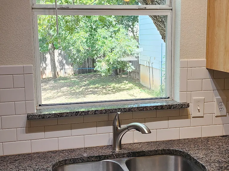 Undermounted sink with granite countertops, great view to backyard