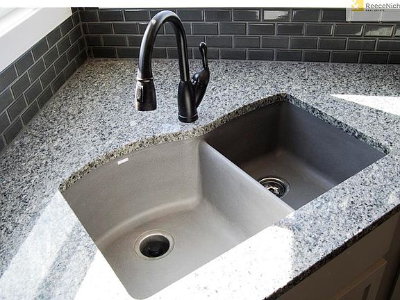 Silgranite kitchen sink and oil-rubbed bronze plumbing fixtures add depth and character to the gorgeous kitchen.