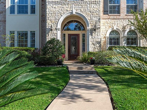 A charming walkway leading to this custom beauty outlined by a brick and stone design is sure to greet your guests in style!