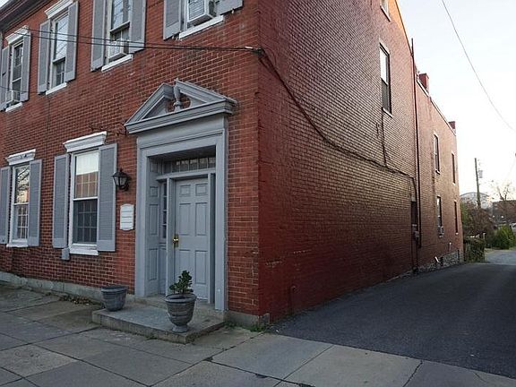 Front, side, and rear of building showing parking area and garage behind building.