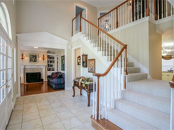 Entry/Staircase and balcony. Study with fireplace flanked by built in bookcases to the left