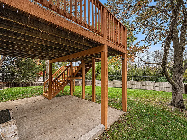 A versatile deck with stairs leading to the backyard, perfect for outdoor meals or gatherings, with a shaded patio underneath for relaxing or entertaining.
