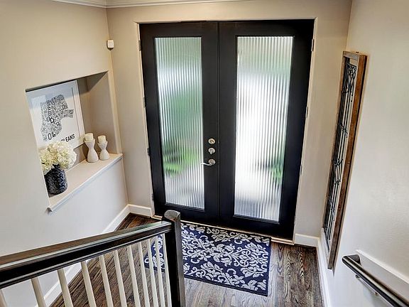 Double door, front entry with lots of natural light, leads to first floor bedroom and bath