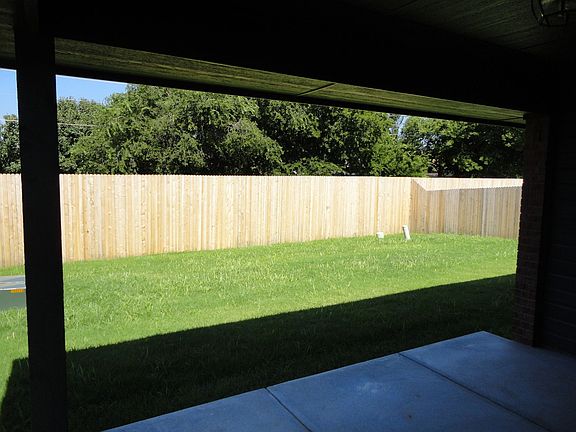 View from covered patio of fenced yard