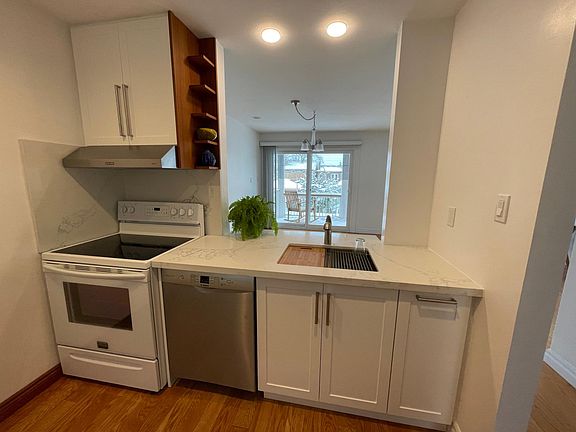 Kitchen open to dining room with view to deck and backyard