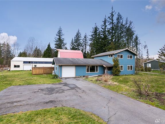 Freshly-painted house exterior. New metal roof on barn.