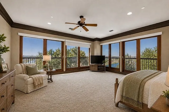 Primary bedroom AI generated staging. Beautiful views of the Trinity River from the sliding doors (windows) in the master bedrooms.